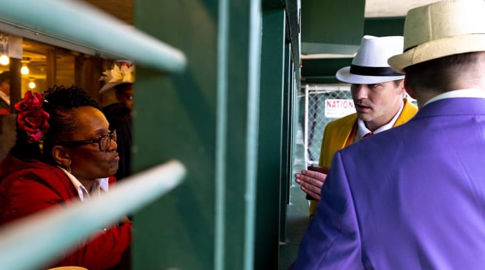 May 7, 2022; Louisville, KY, USA; Trudy Bates, Churchill Downs mutual clerk, speaks to Eric Riedesel, of Wisconsin, about a bet on the day of the Kentucky Derby at Churchill Downs.
